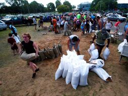 Residentes llenan bolsas con arena para improvisar diques, en el pueblo de Townsville. AFP  /