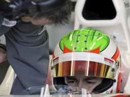 El piloto mexicano del equipo Sauber, Sergio Pérez, observa los ajustes que hace un mecánico en el interior de su monoplaza. EFE  /