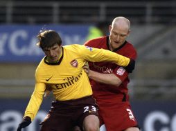 El ruso del Arsenal, Andrey Arshavin, es marcado por el defensa del Leyton, Andrew Whing. AFP  /