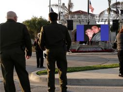 Familiares y amigos de Jaime Zapata ven presentación de diapositivas a su llegada al funeral. AP  /