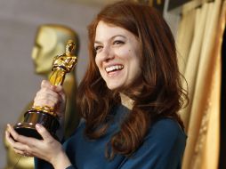 Una mujer posa con la estatuilla dorada en la exposición Conoce a los Óscar que se exhibe en la estación Grand Central de Mahattan en  /