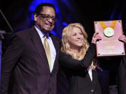 La cantante recibe su reconocimiento junto al director de la institución, Allen Counter. AP  /