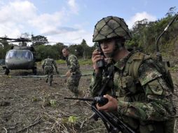 Soldados montan guardia cerca del lugar donde explotó una embarcación durante el atentado atribuido a las FARC. EFE  /