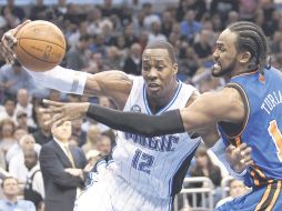Dwight Howard (izq.), de Orlando, conduce el balón ante la marca de Ronny Turiaf, de los Knicks de Nueva York. AP  /