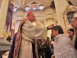El cardenal, Juan Sandoval Íñiguez, durante la imposición de ceniza a los fieles esta mañana. S. NÚÑEZ  /