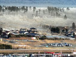 Una serie de olas se interna en tierra firme en Natori, Estado de Miyagi. REUTERS  /