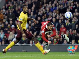 El arquero del Arsenal, Manuel Almunia (izq.), detiene un  cabezazo del “Chicharito”, que originó el primer gol del 'ManU'. REUTERS  /