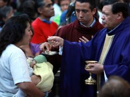 Norberto Rivera ofrece la comunión a una mujer en el primer domingo de Cuaresma. EL UNIVERSAL  /