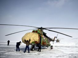 Miembros del servicio ruso de Búsqueda y Rescate protegen sus helicópteros tras aterrizar en Arkalyk. EFE  /
