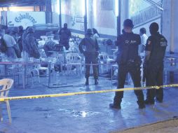 Policías federales, militares y peritos de criminalística, revisan la escena del crimen, en el Puerto guerrerense. EL UNIVERSAL  /