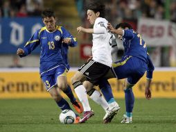 El alemán Mesut Özil (centro) lucha por el control del balón con jugadores de la selección de Kazajistán. EFE  /