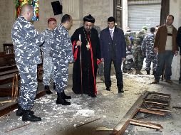Miembros de la policía libanesa y un arzobispo sirio inspeccionan el lugar de la explosión. EFE  /