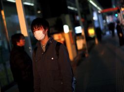 Un joven con cubreboca recorre las afueras de Fukushima. REUTERS  /