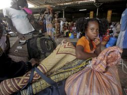 Marfileños se concentran en una estación de buses para salir de Abidján. EFE  /