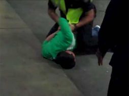 Momento que el aficionado de México es sometido por la policía. ESPECIAL tomado del video en YouTube  /