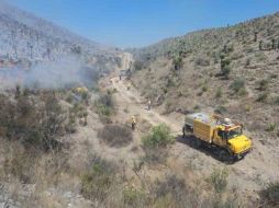 Una brigada de apagafuegos se auxilia con un camión cisterna. EL UNIVERSAL  /