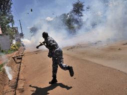 Un policía lanza una bomba de gas lacrimógeno durante la  protesta. ARCHIVO  /