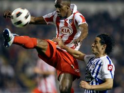 Andrés Guardado (der.) pelea por la pelota con Luis Perea. REUTERS  /