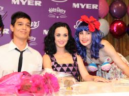 La artista posa con dos admiradores durante la presentación de su nueva esencia. NTX  /