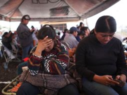 Familiares de los trababajadores atrapados aguardan afuera de la mina. AP  /