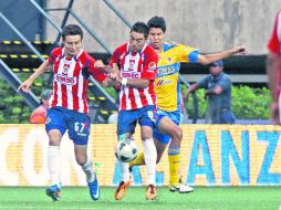 Érick Torres y Marco Fabián disputan la pelota con Hugo Ayala, de Tigres. MEXSPORT  /