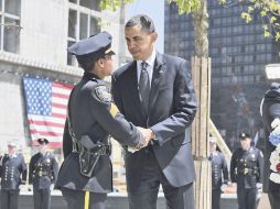 Barack Obama saluda a un oficial neoyorkino, durante los honores a las víctimas del S-11, en la Zona Cero de Nueva York. REUTERS  /