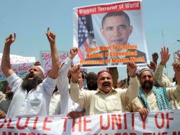Varias personas protestan mientras sostienen una fotografía del presidente de EU, Barack Obama, en Multan, Pakistán. EFE  /