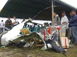 Un grupo de personas observa una de las partes destruidas del avión que se estrelló en el Mar en Kaimana, provincia de Papúa. AP  /