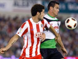 El central del Racing, Tziolis (d), pugna por un balón con el centrocampista del Atlético de Madrid, Mario Suárez. EFE  /