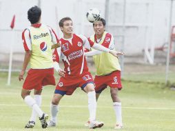 Érick Torres (centro), la joya más reciente de las fuerzas básicas de Chivas, disputa la pelota con Omar Esparza (der.). E. PACHECO  /