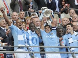 El capitán del equipo, Carlos Tévez, levanta el trofeo junto a sus compañeros tras vencer al Stoke City. EFE  /