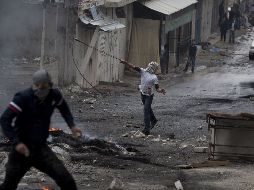 Varios palestinos lanzan piedras a la policía israelí durante los enfrentamientos. EFE  /