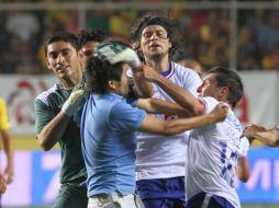 Los jugadores de La Máquina golpeando al aficionado que entró a la cancha y provocó la pelea en el estadio Morelos. NTX  /