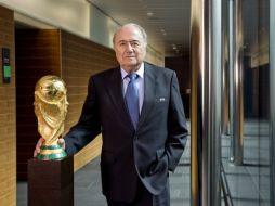 El presidente de la FIFA, Joseph Blatter junto un trofeo mundialista. AFP  /