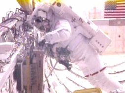 Greg Chamitoff recupera un experimento de la bodega de carga durante la caminata espacial. REUTERS  /