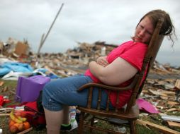 Una chica se sienta junto a los restos de su casa en Joplin, Missouri. Habitantes de Illinois temen a los tornado en su Entidad. AP  /