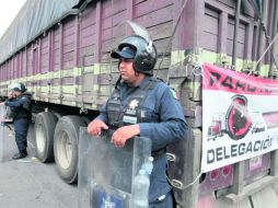 Elementos de la Policía Federal resguardan los camiones para evitar bloqueos en la carretera Toluca-México. EL UNIVERSAL  /