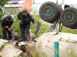 Un perito inspecciona la aeronave que quedó destruida por el impacto. AFP  /