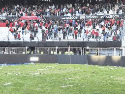 Trozos de las butacas invadieron la cancha del Monumental. EFE  /