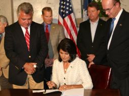 La gobernadora de Carolina del Sur, Nikki Haley (c), firma hoy la ley SB20, que criminaliza a los indocumentados. EFE  /