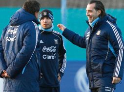 'Kun' (centro) platicó ayer al final de la práctica con el técnico Sergio Batista (der.) y sus auxiliares. AFP  /