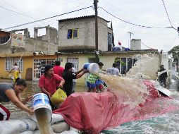 Habitantes de la colonia Franja Valle de México en Ecatepec, en el Estado de México intentan bajar el nivel del agua. EFE  /