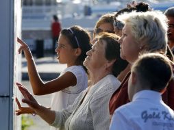 Familiares de los pasajeros del barco ''Bulgaria'' leen las listas con los nombres de las víctimas. EFE  /