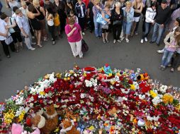 Varias personas colocan velas y flores en conmemoración de las víctimas del ''Bulgaria''. EFE  /