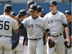 Nick Swisher (Cent.) y el pitcher Boone Logan (Der.) celebran el trunfo sobre los Azulejos. AP  /