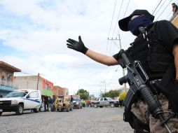 Un policía municipal resguarda la zona donde fue victimado un hombre en la Colonia Canal 58 de Tlaquepaque. O. RUVALCABA.  /