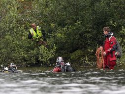Buzos de búsqueda se encuentran en la orilla de la pequeña isla, bosques de Utoeya. REUTERS  /