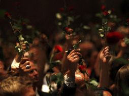 Personas sostienen rosas rojas durante una reunión conmemorativa a las víctimas de los ataques del viernes pasado. REUTERS  /