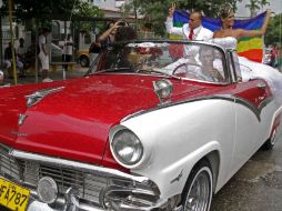 Los nuevos esposos desfilan en un auto clásico descapotable. REUTERS  /