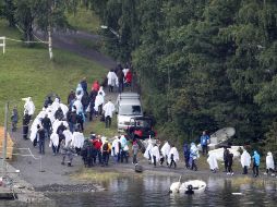 Sobrevivientes y familiares de los fallecidos asisten a la isla de Utoya. AP  /
